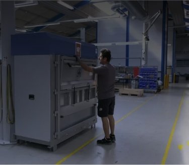 homme dans un environnement de fabrication utilisant une grande presse Mil-tek