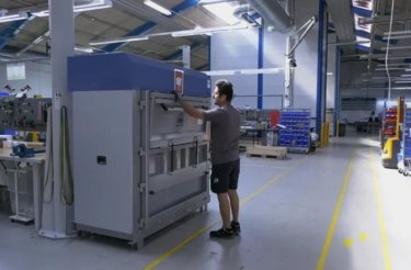un homme utilise une presse dans une installation de fabrication lean
