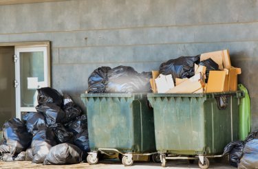 conteneurs verts extérieurs débordant de déchets